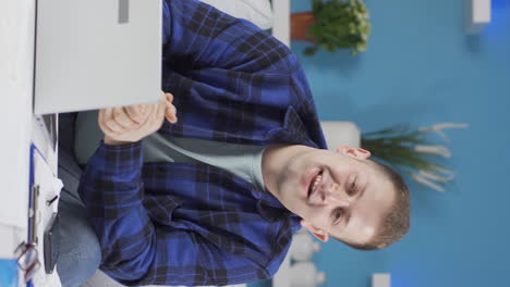 Vertical-video-of-Home-office-worker-man-looking-smugly-at-camera.